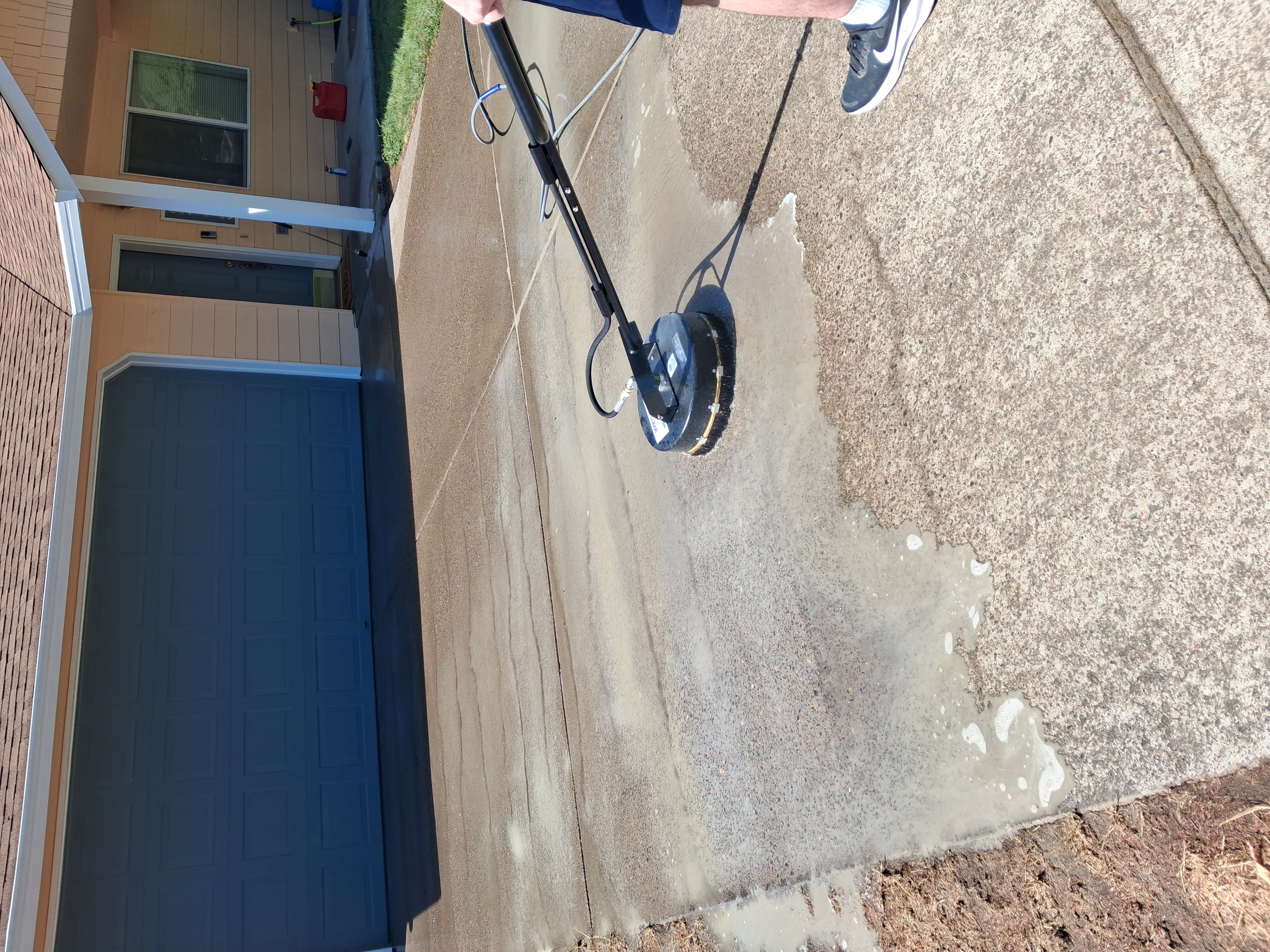 Rotary surface cleaner washing a residential driveway